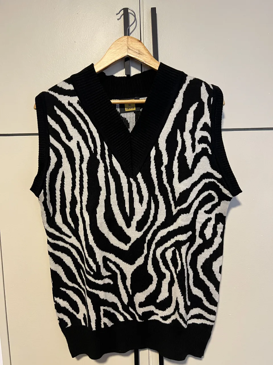 Chaleco de punto con estampado de cebra en blanco y negro. Diseño oversize con cuello en V y sin mangas. Ideal para un look canchero y moderno.
largo a hombro: 62
ancho axila a axila: 50
