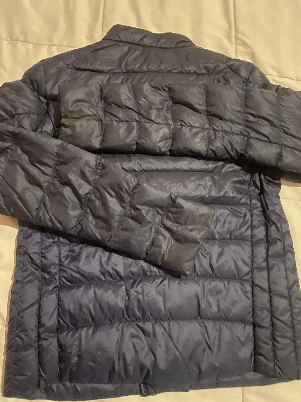 Campera de pluma Uniqlo azul marino, talle XS, ideal para el invierno. Liviana y abrigada, perfecta para el día a día.