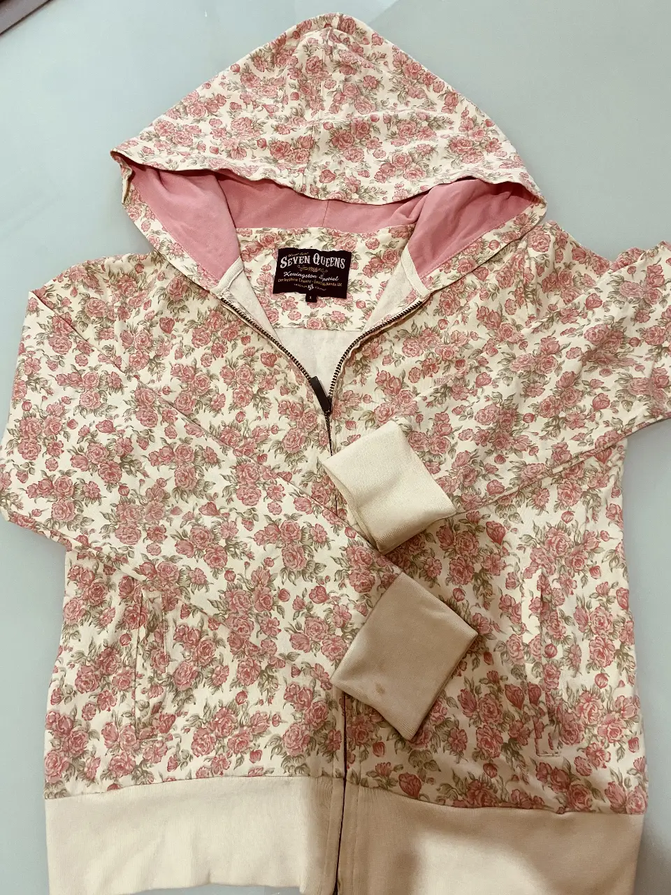 Buzo con cierre y capucha, estampado floral en tonos rosas y blancos. Ideal para un look casual y femenino. Confeccionado con materiales suaves y cómodos.