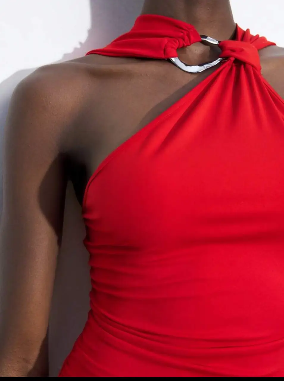 Vestido midi rojo con diseño asimétrico y detalle de aro metálico en el cuello. Ideal para eventos especiales o salidas nocturnas. Corte ajustado que realza la figura.