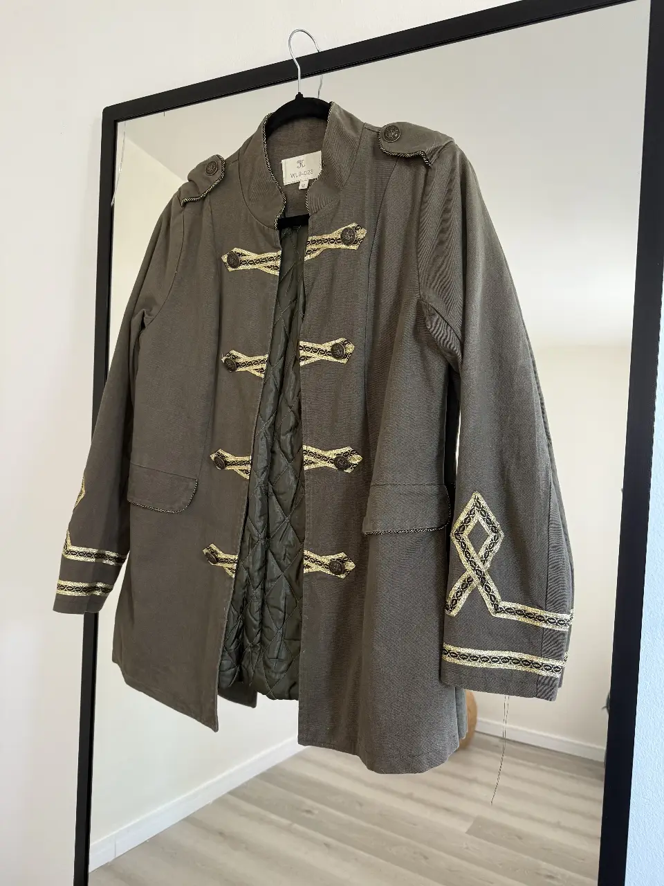 Campera estilo militar en color verde con detalles dorados. Posee botones decorativos y detalles bordados en las mangas. Ideal para un look sofisticado y con estilo. Talle 36 equivalente a talle S.