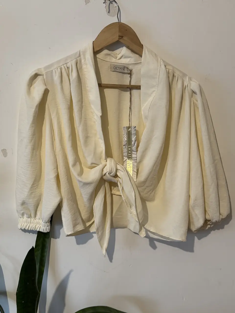 Blusa de mujer color crudo con detalle de lazo en la cintura y mangas abullonadas. Ideal para un look elegante y sofisticado.