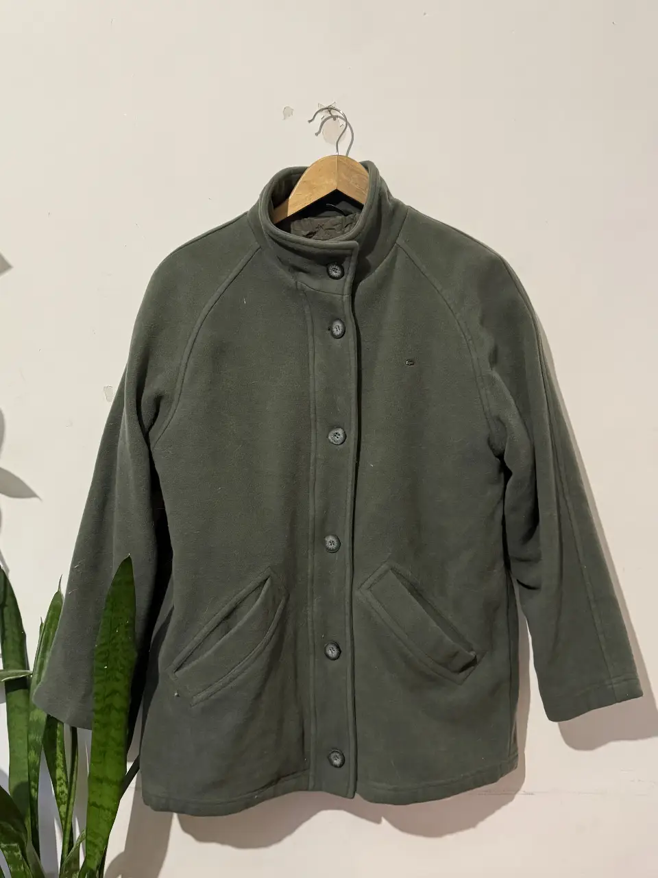 Campera Lacoste de paño verde oscuro, con botones y cierre frontal. Posee dos bolsillos delanteros y forro interior con diseño acolchado. Ideal para el invierno.