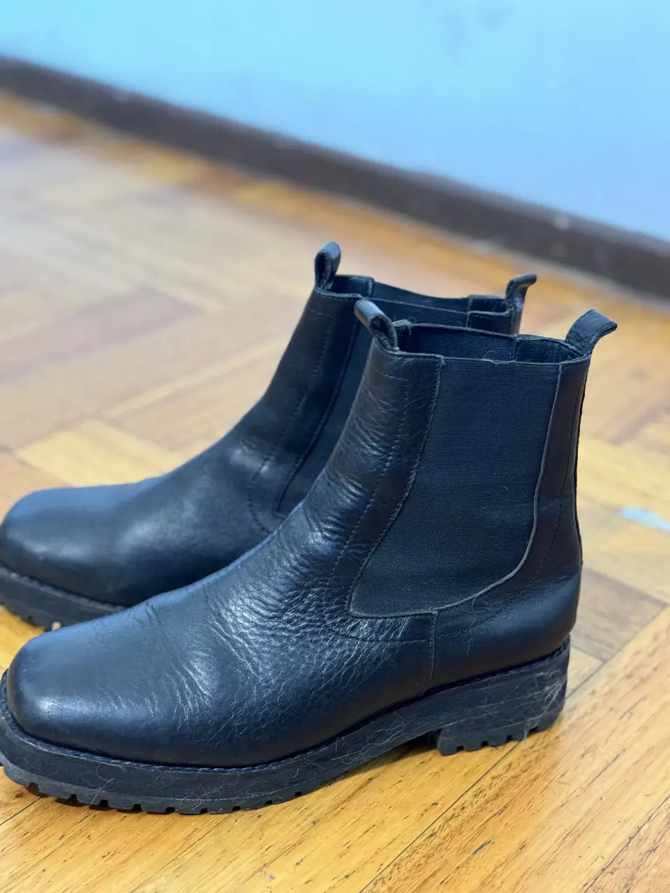 Botines negros de cuero con suela gruesa y detalle de la marca LOVE JUSTA en el lateral. Ideales para un look moderno y urbano. Igual a nuevas