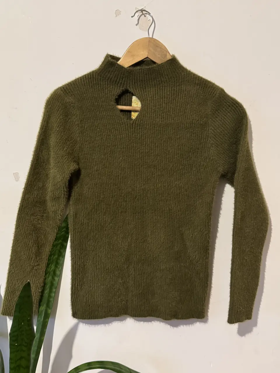 Sweater de cuello alto con abertura en el pecho. De color verde oscuro, ideal para el invierno. Confeccionado en una mezcla de algodón y poliéster, este sweater es suave y abrigado. Perfecto para un look casual y cómodo.