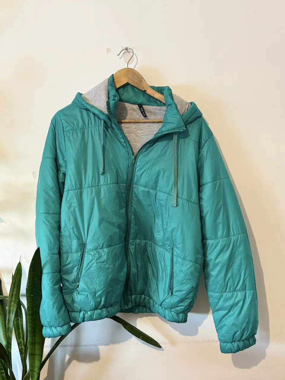 Campera deportiva acolchada de color verde turquesa con capucha y cierre. Ideal para actividades al aire libre o para un look casual y abrigado.
