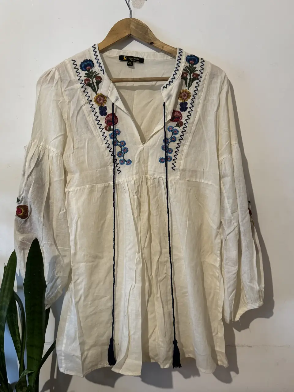 Blusa blanca con bordados florales en el cuello y mangas. Estilo boho, ideal para un look casual y fresco. viene con forro