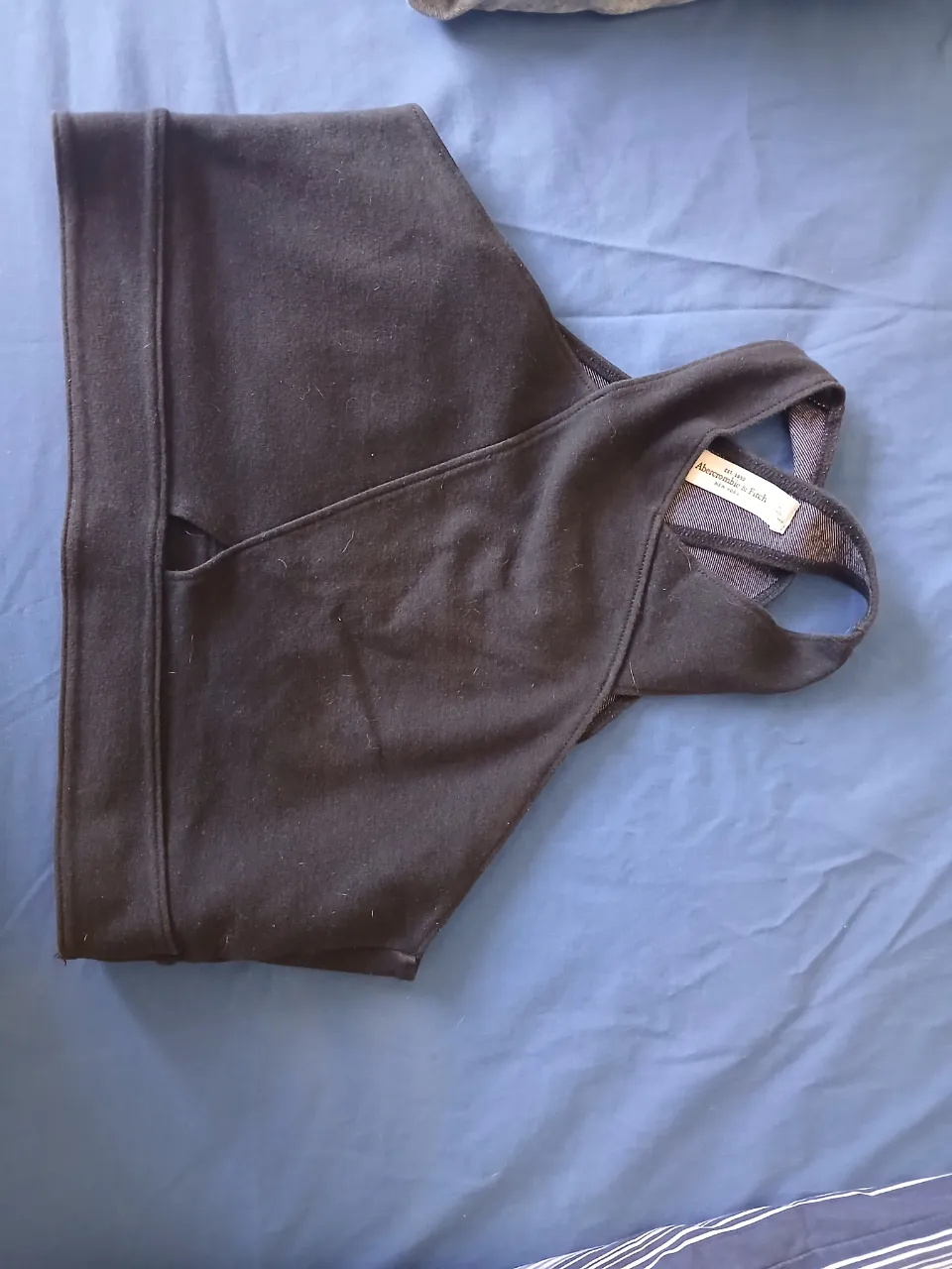 Top deportivo negro con tiras cruzadas en la espalda. Posee etiqueta de la marca Abercrombie & Fitch.