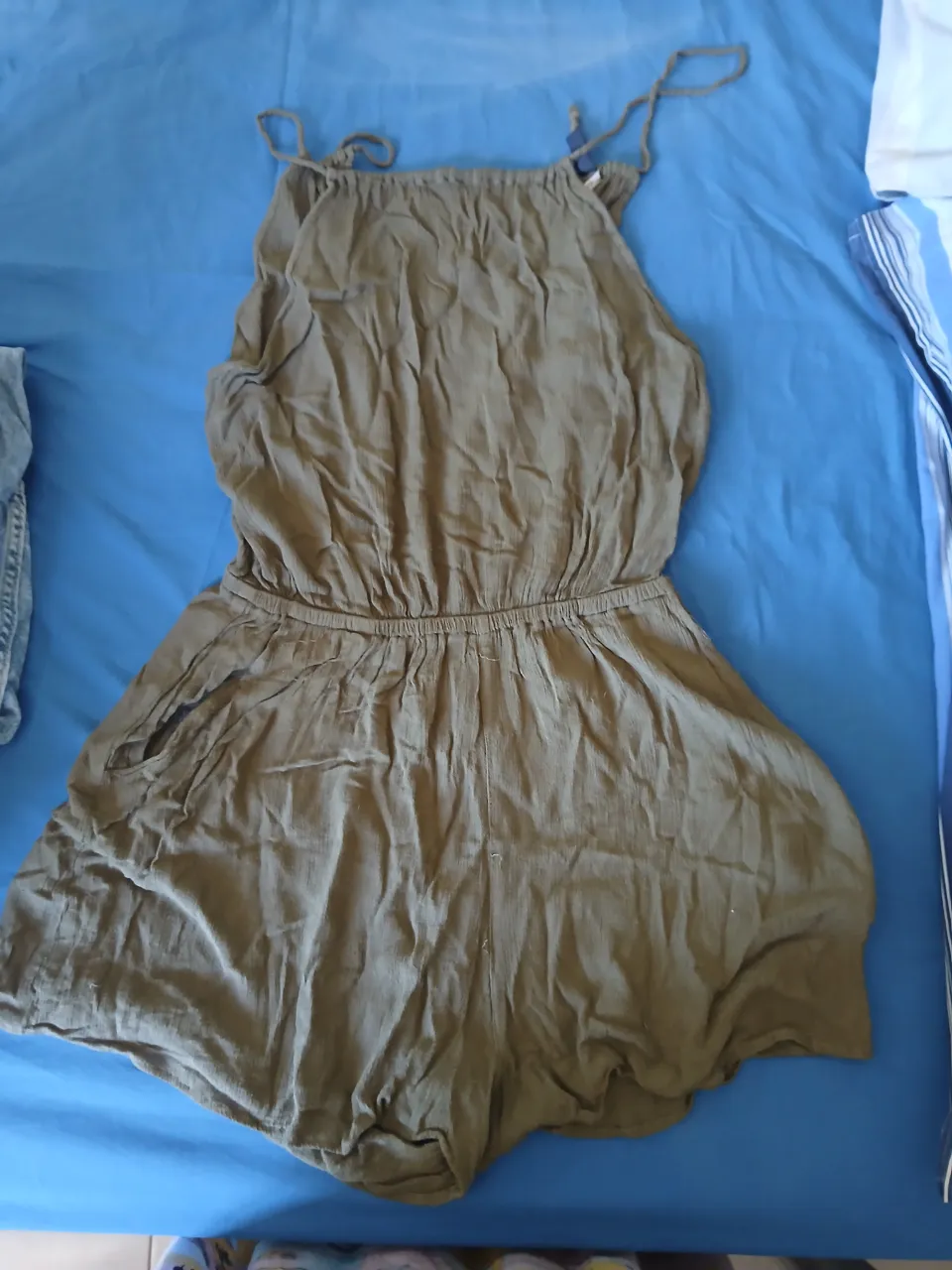 Mono corto de tela color verde militar. Breteles finos regulables. Cintura elastizada. Escote en V con lazo.