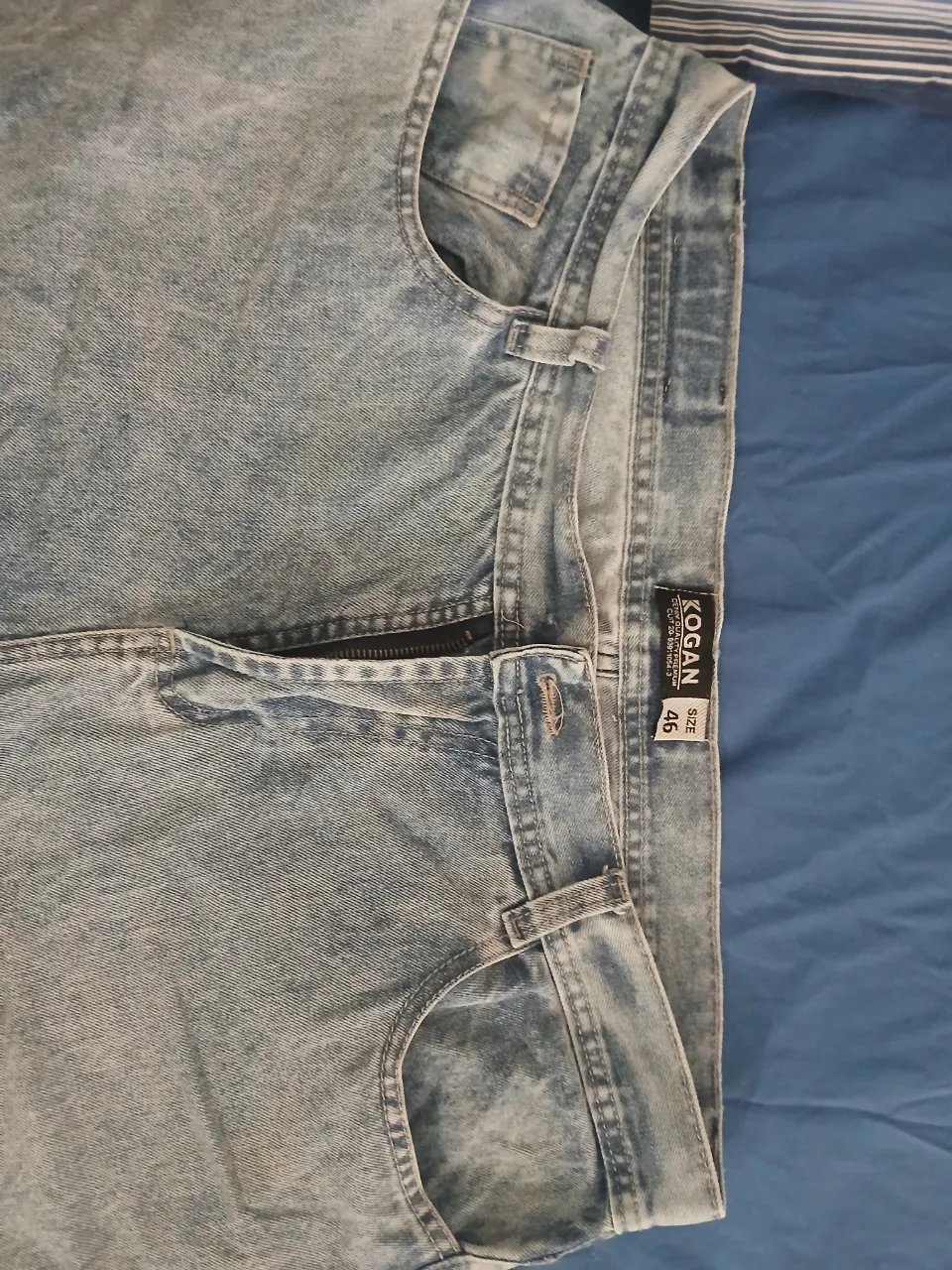 Jeans de algodón color celeste con efecto desgastado. Cuentan con cierre y le falta el boton