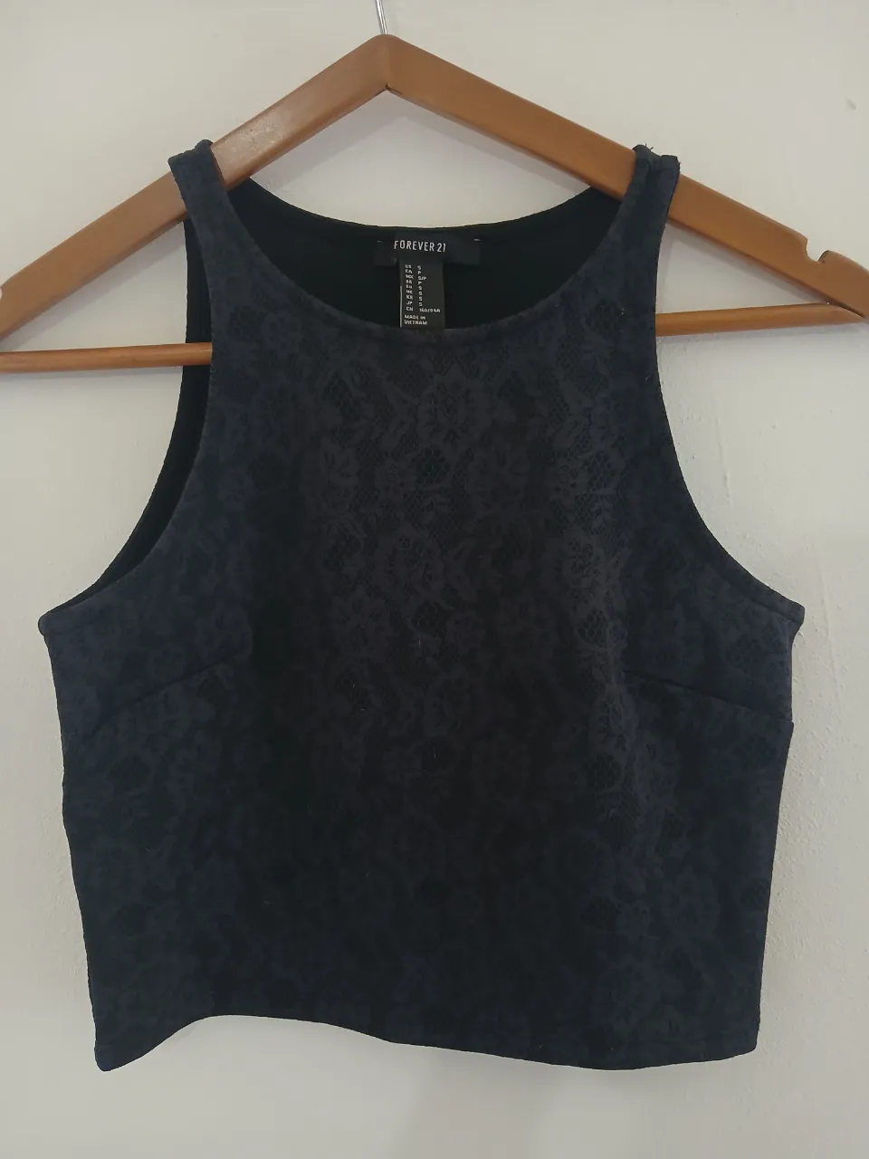 Top negro con textura floral en relieve. Diseño sin mangas y escote redondo.