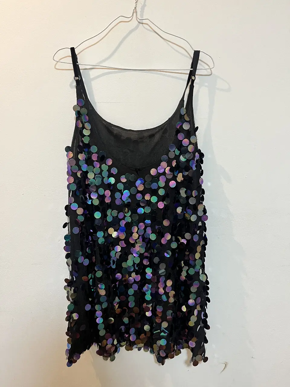 Vestido mini negro con lentejuelas tornasoladas, ideal para fiestas y eventos especiales. Diseño moderno y llamativo.
