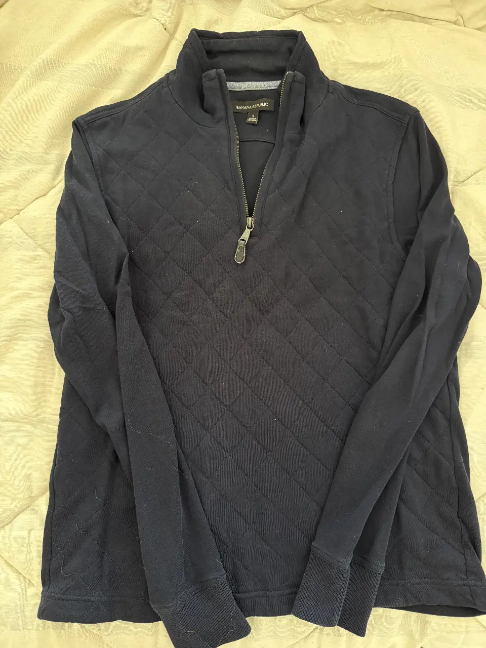 Buzo con cierre para hombre, de color azul marino, con diseño acolchado en rombos. Ideal para un look casual y abrigado.