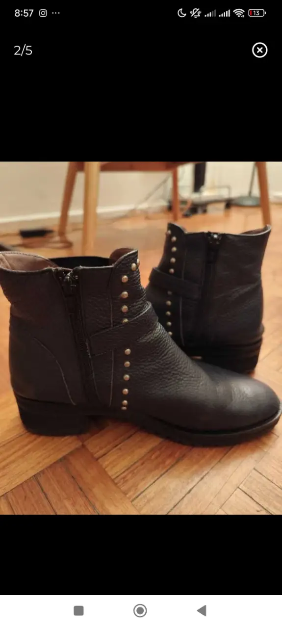 Botines de cuero azul con detalles de tachas plateadas. Diseño moderno y versátil, ideales para combinar con diferentes outfits.