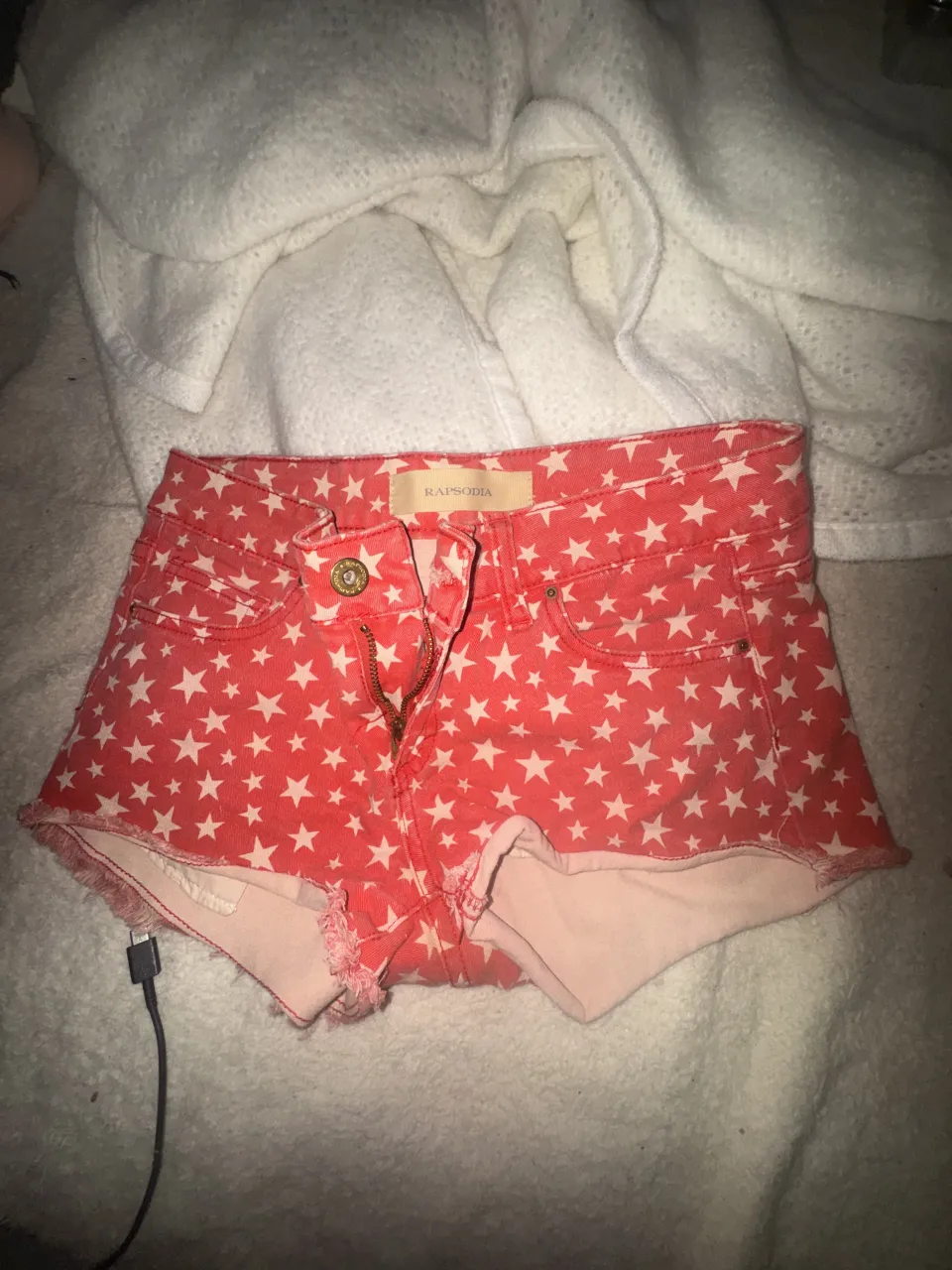 Rapsodia. 
Pedime las medidas 
Shorts de jean súper cancheros con estampa de estrellas rojas y blancas. Tienen un corte desgastado en los bordes que le da un toque moderno y descontracturado. Ideales para un look casual y divertido.