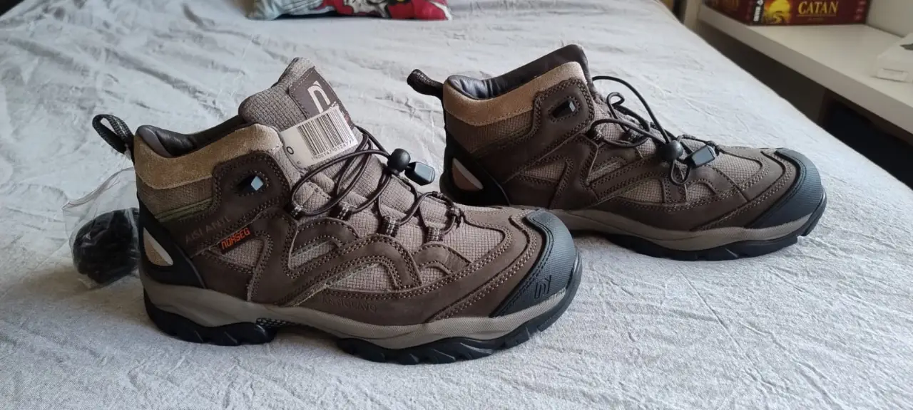 Botas de trekking Norseg para hombre, impermeables, ideales para actividades al aire libre. Diseño robusto en tonos marrones y grises, con ajuste de cordones y suela resistente.