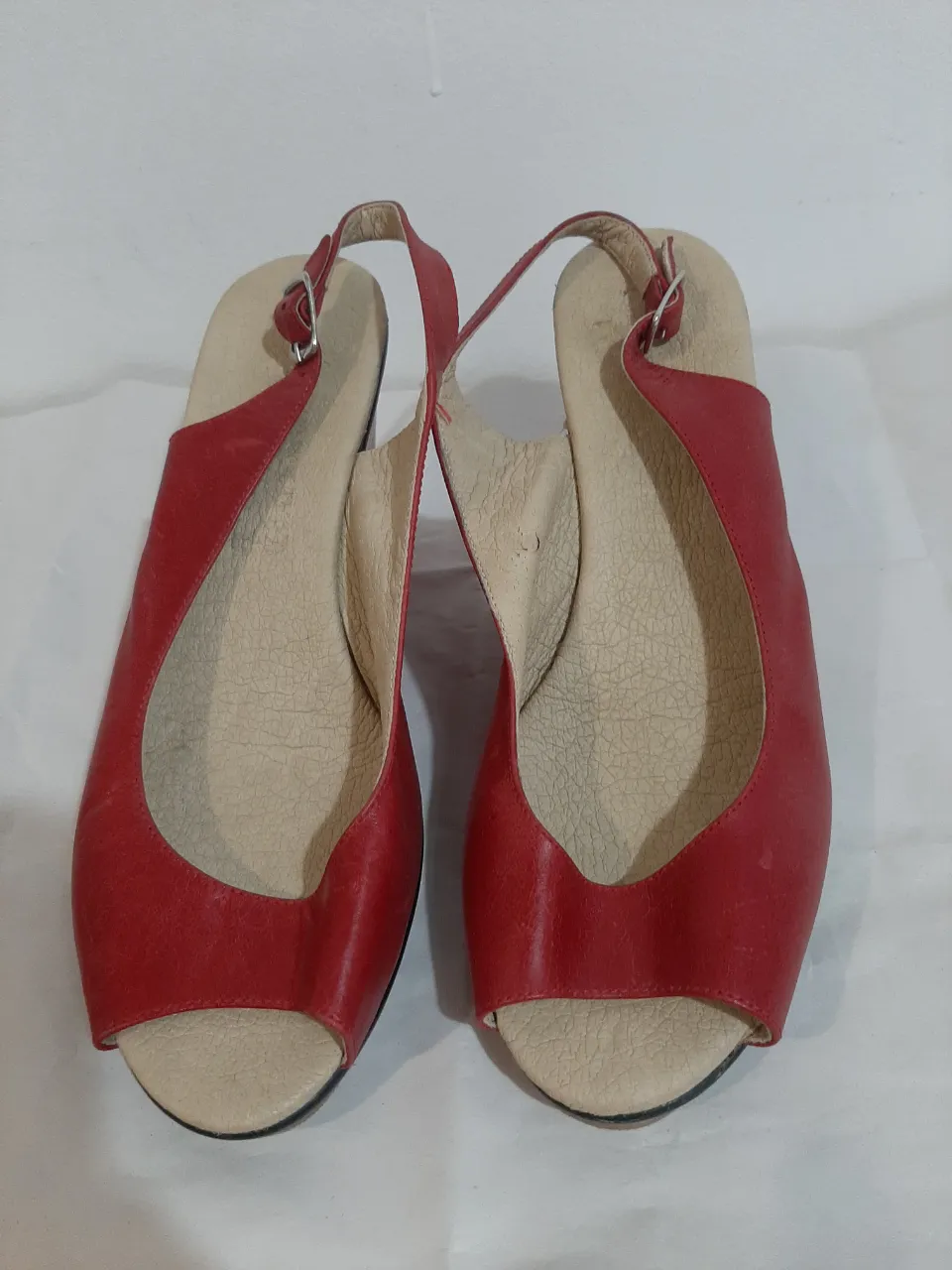 Sandalias de cuña rojas, con tiras y hebilla. Ideales para un look canchero y cómodo.
