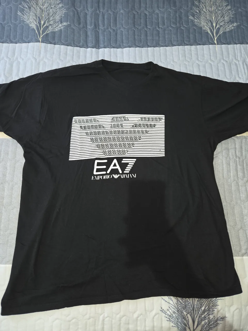 Remera negra de manga corta con estampa gráfica blanca en el frente. La estampa incluye el logo de la marca.