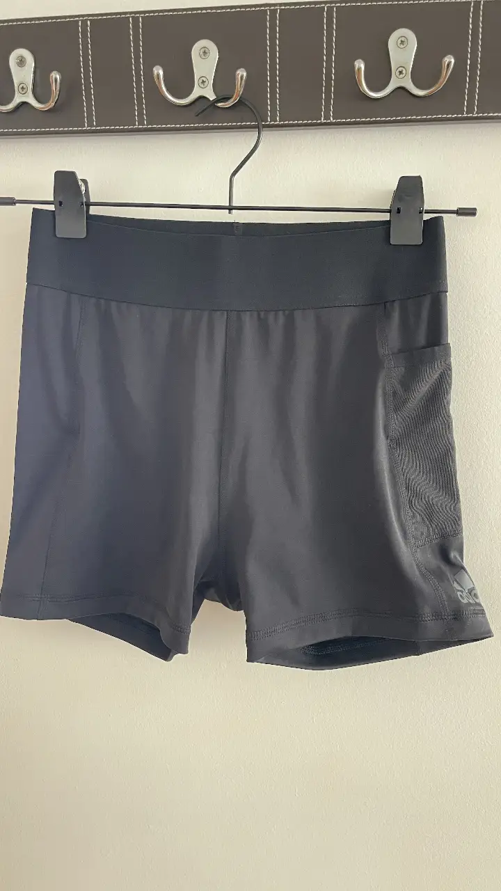 Short deportivo negro de la marca Adidas, ideal para actividades físicas. Cuenta con un bolsillo lateral y tecnología Aeroready para mayor comodidad y transpirabilidad. Perfecto para tus entrenamientos.