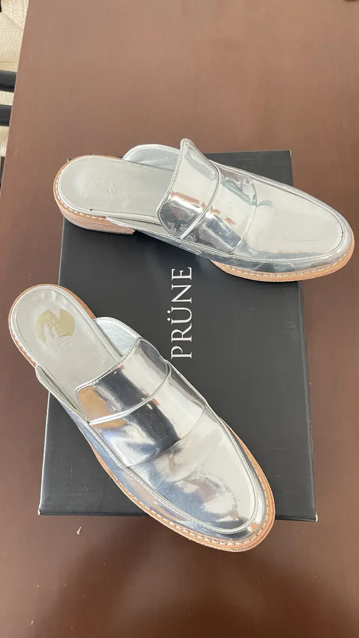 Sandalias Prüne plateadas, estilo mocasín, con detalle de costura en la suela y plantilla de cuero. Talle 37.