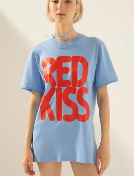 Remera de algodón celeste con estampado "RED KISS" en rojo. Ideal para un look casual y moderno.