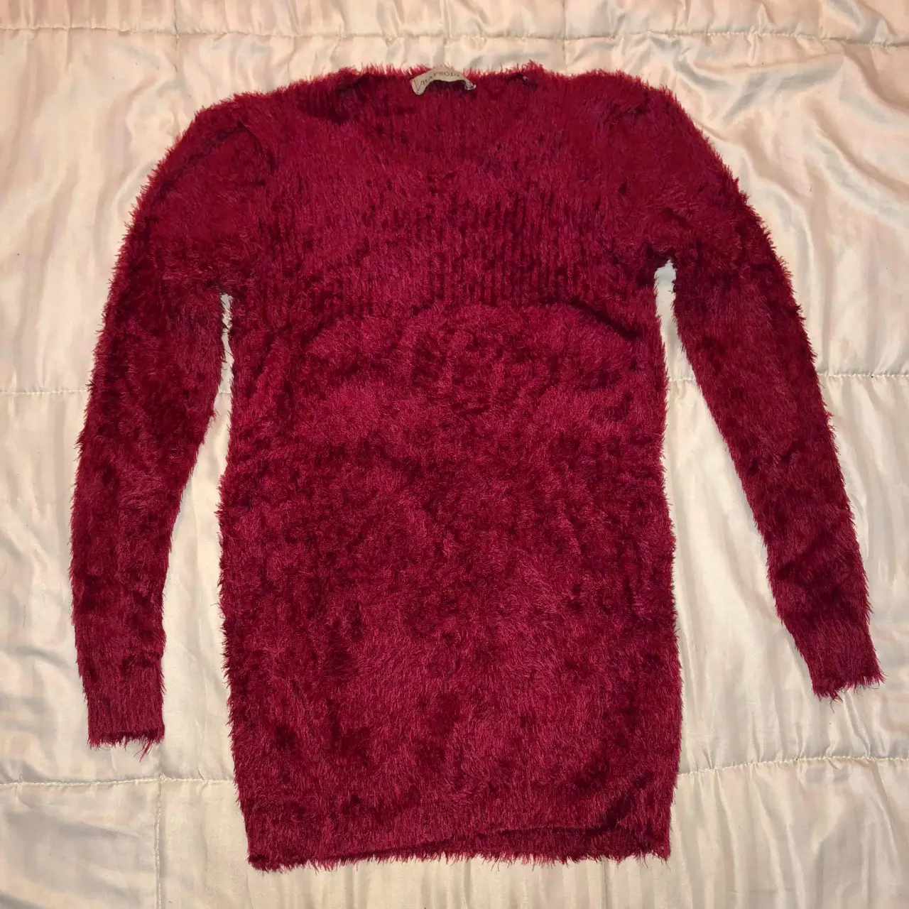 Sweater de mujer color bordó, tejido peludo, ideal para el invierno. Cuello en V y mangas largas. Perfecto para un look casual y abrigado.