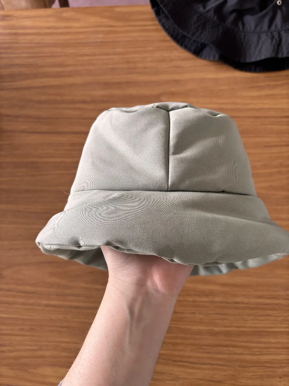 Sombrero bucket reversible, de color gris claro y negro. Ideal para protegerse del sol con estilo.