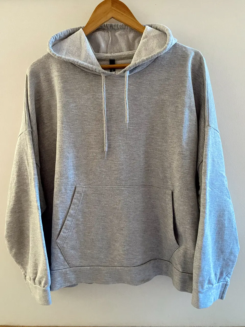 Buzo Nuevo - Gris . Cuenta con un bolsillo frontal tipo canguro y capucha con cordones ajustables. 