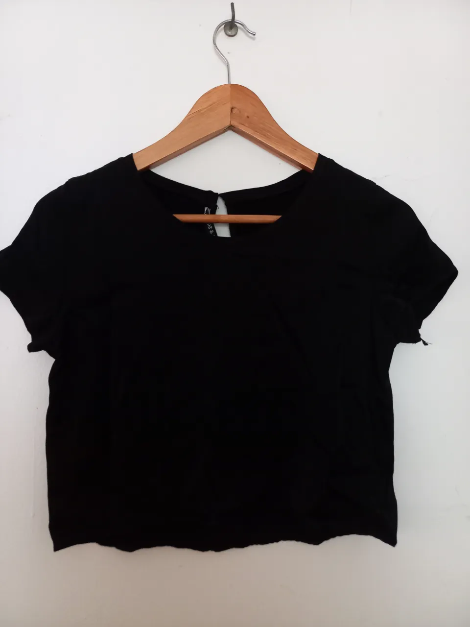 Top negro corto, ideal para un look casual y moderno. Su diseño versátil lo hace perfecto para combinar con jeans, faldas o shorts, adaptándose a diferentes ocasiones.