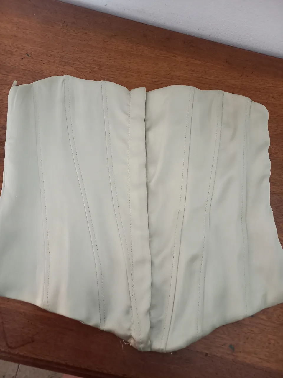 Top tipo corset de satén color crudo. Diseño ajustado al cuerpo con ballenas para dar forma. Ideal para looks de fiesta o para darle un toque elegante a un outfit casual.