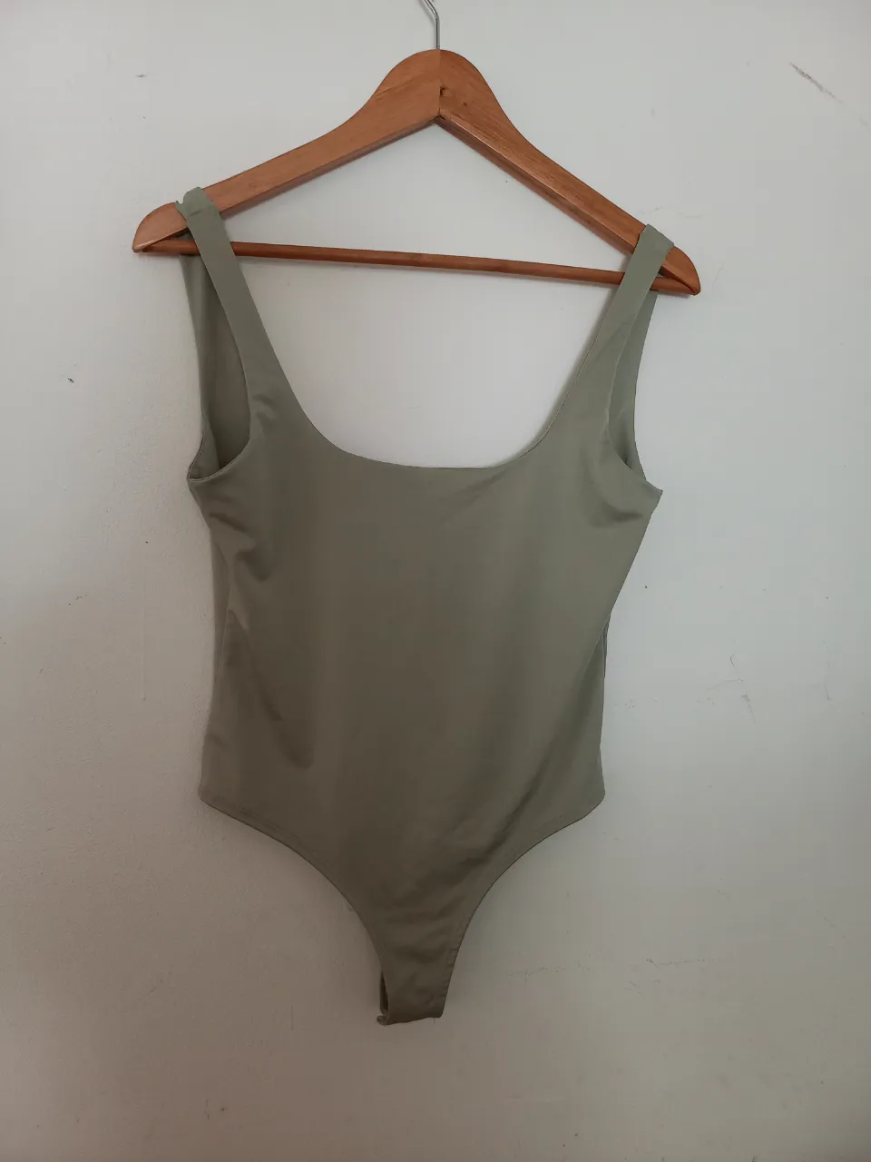 Body de lycra color verde musgo, con escote cuadrado y espalda baja. Ideal para usar como traje de baño o como prenda de vestir.