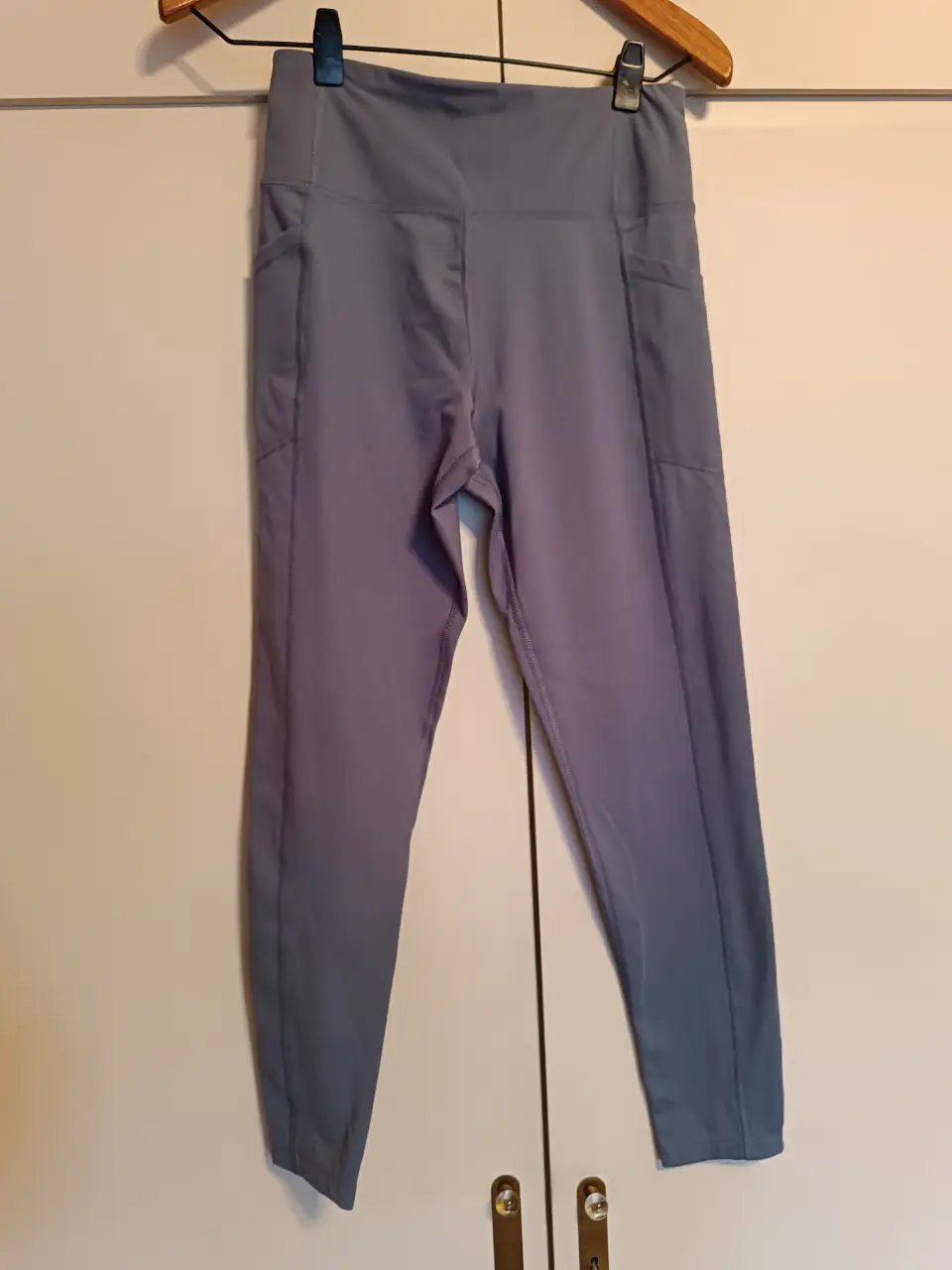 Calzas deportivas de mujer, color gris, con bolsillos laterales. Ideal para entrenamientos y actividades físicas. Marca Calvin Klein Performance.