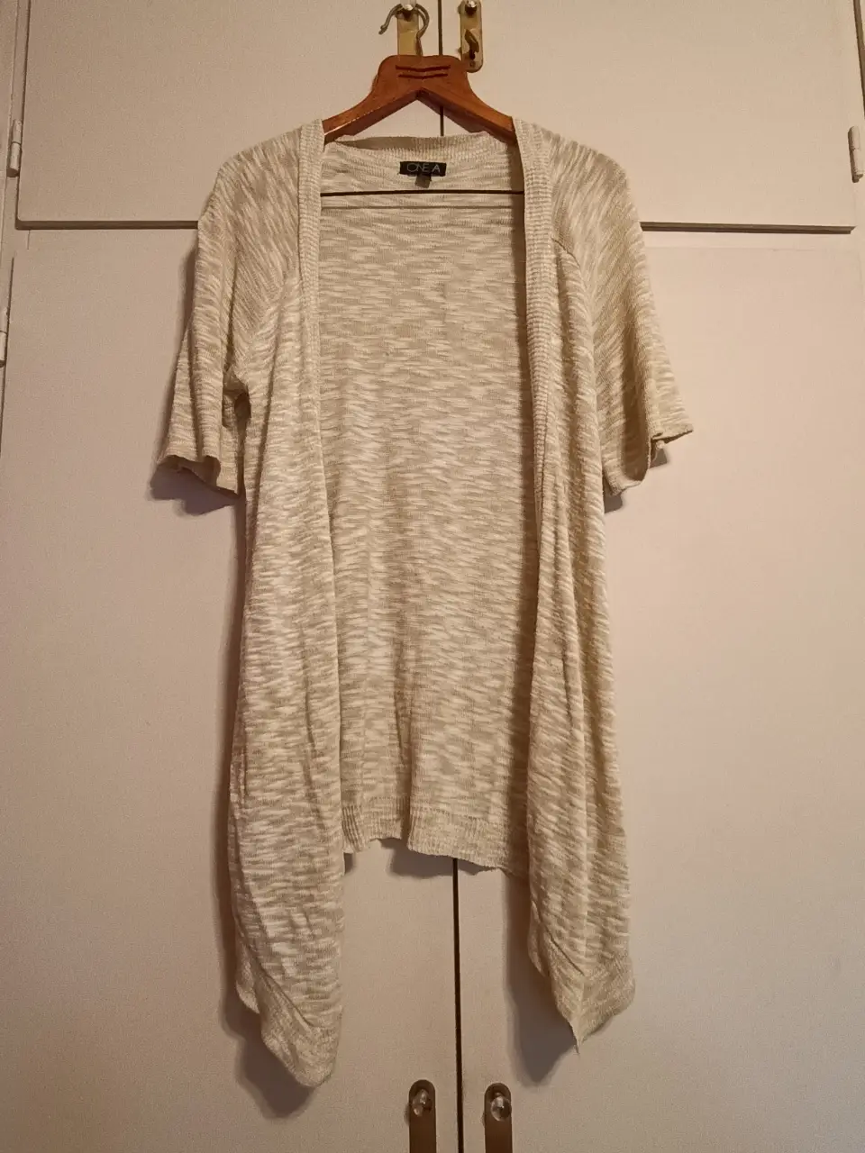 Cardigan abierto de manga corta en color crudo, ideal para un look casual y fresco. Perfecto para combinar con diferentes outfits.