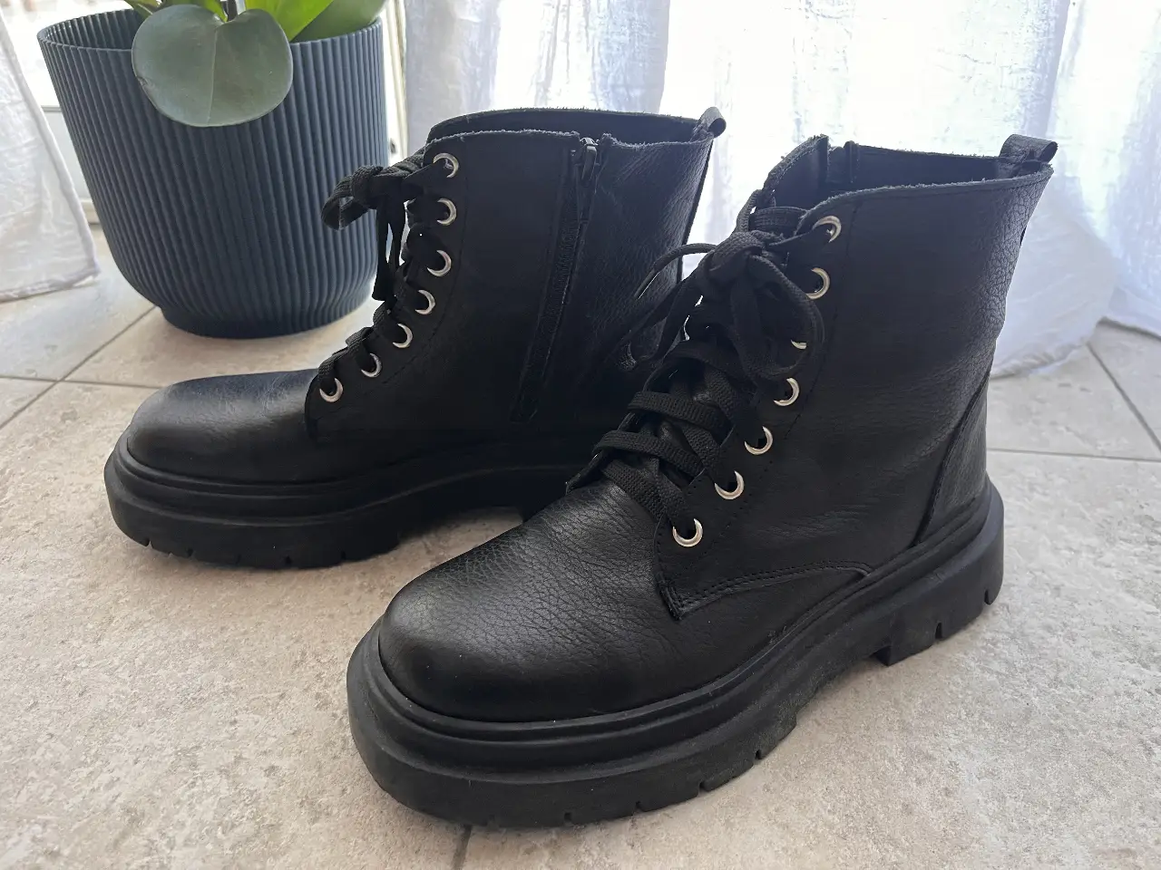 Borcegos negros de cuero natural con forro sintético, con suela gruesa y cordones y cierre lateral. Ideales para un look urbano y moderno. como nuevos 