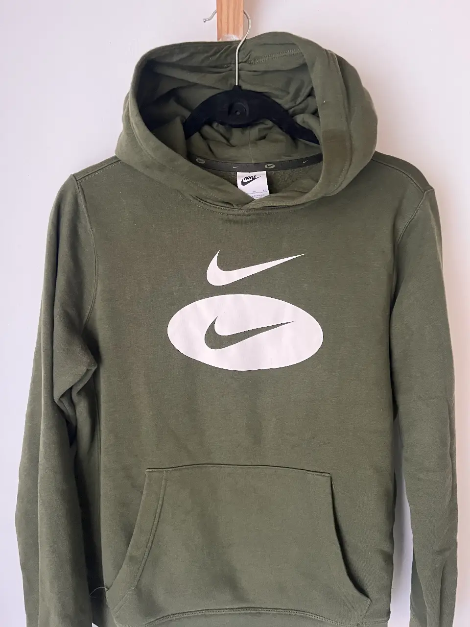 Buzo canguro Nike verde oscuro con logo blanco. talle G de niños, S/M de mujer. Ideal para un look casual y cómodo.