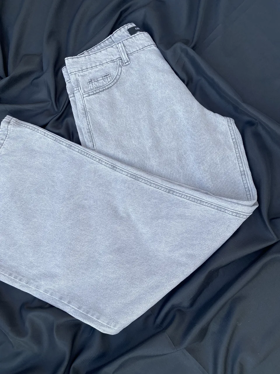 Pantalón de jean oversize de color gris claro, ideal para un look casual y moderno. Perfecto para combinar con diferentes estilos y crear outfits versátiles.