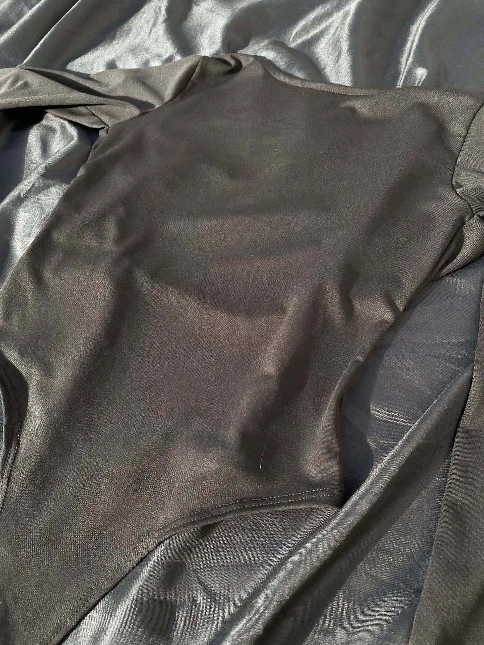 Body negro de manga larga con espalda descubierta. Ideal para un look moderno y elegante.
