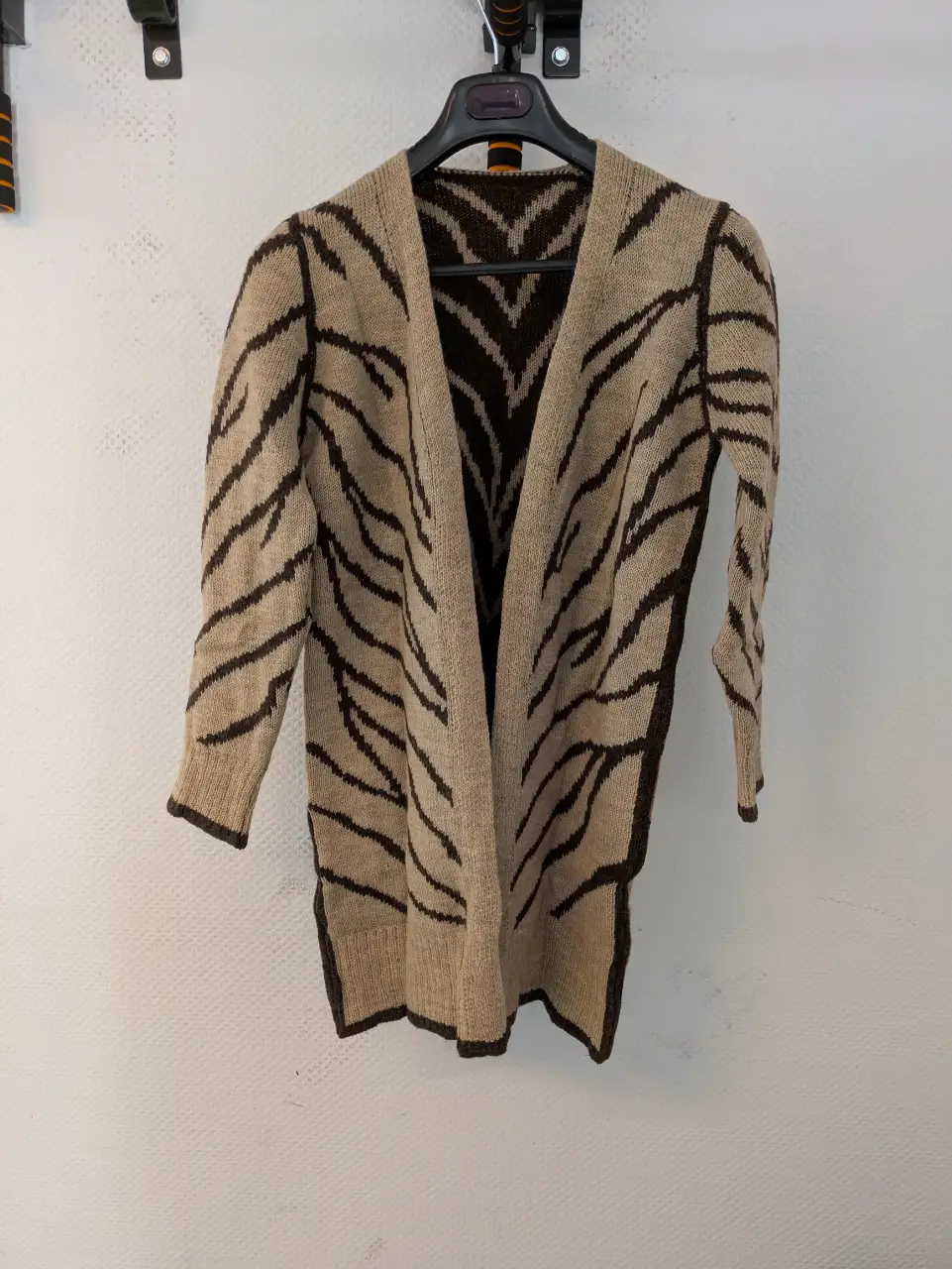 Cardigan largo con estampado de rayas en tonos marrones y beige. Ideal para un look casual y abrigado.