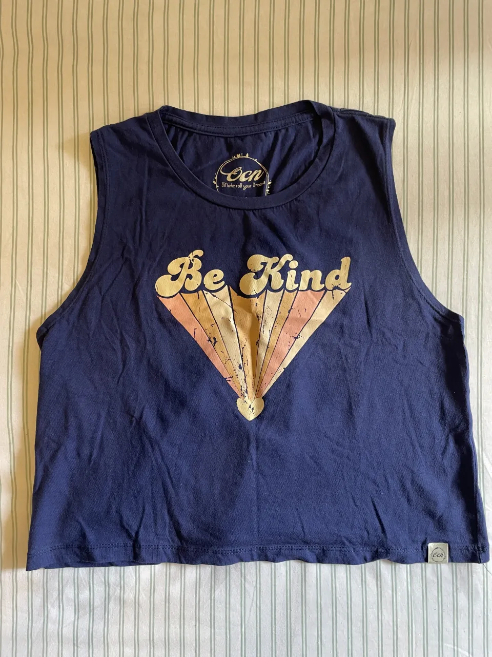 Musculosa OCN azul marino con estampa "Be Kind" en el frente.