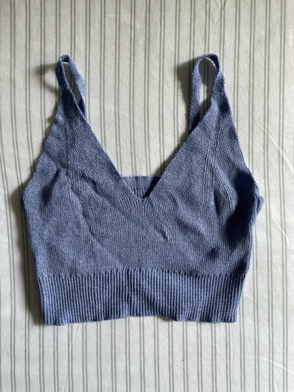 Top tejido de punto color azul claro/ lila . Posee breteles finos y escote en V.