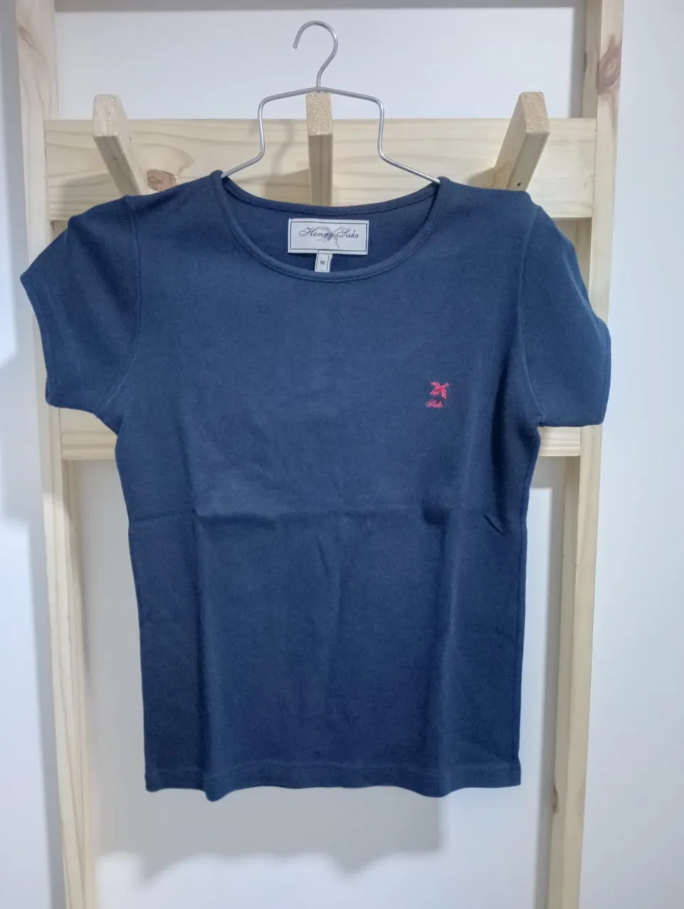 Remera azul marino de manga corta con un pequeño bordado de un animalito en color rojo. Ideal para un look casual y cómodo.