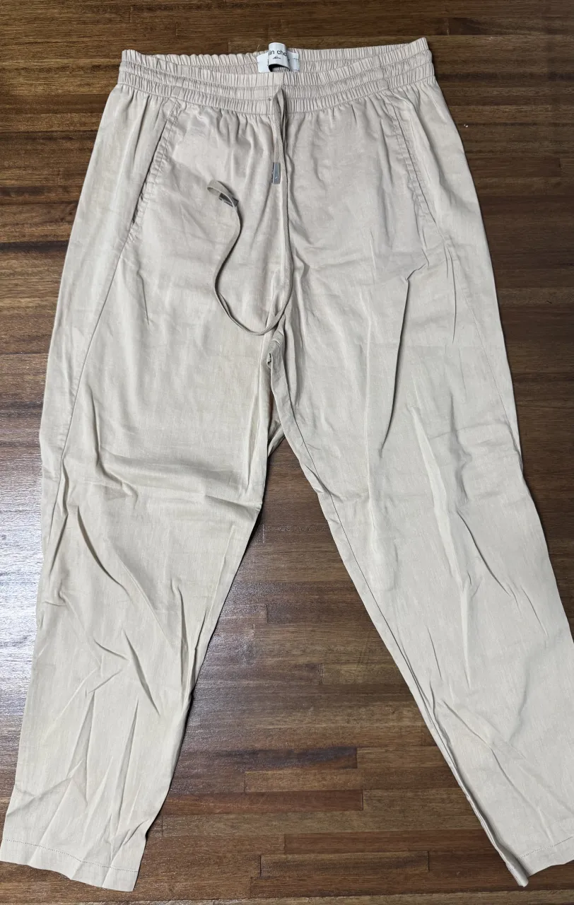 Pantalón de vestir color tiza, tiro alto con elástico en la cintura y cordón para ajustar. Corte recto y moderno, ideal para un look casual o elegante.