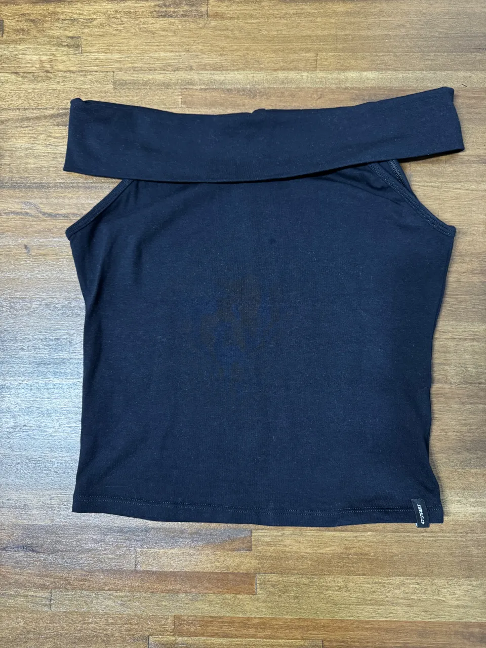 Remera negra con escote descubierto, mangas cortas 