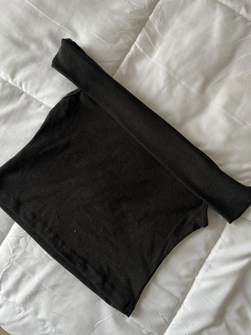 Top negro de diseño moderno, ideal para un look casual y versátil. Confeccionado en tejido de punto acanalado, este top ofrece un ajuste cómodo y favorecedor. Perfecto para combinar con jeans, faldas o pantalones de vestir.