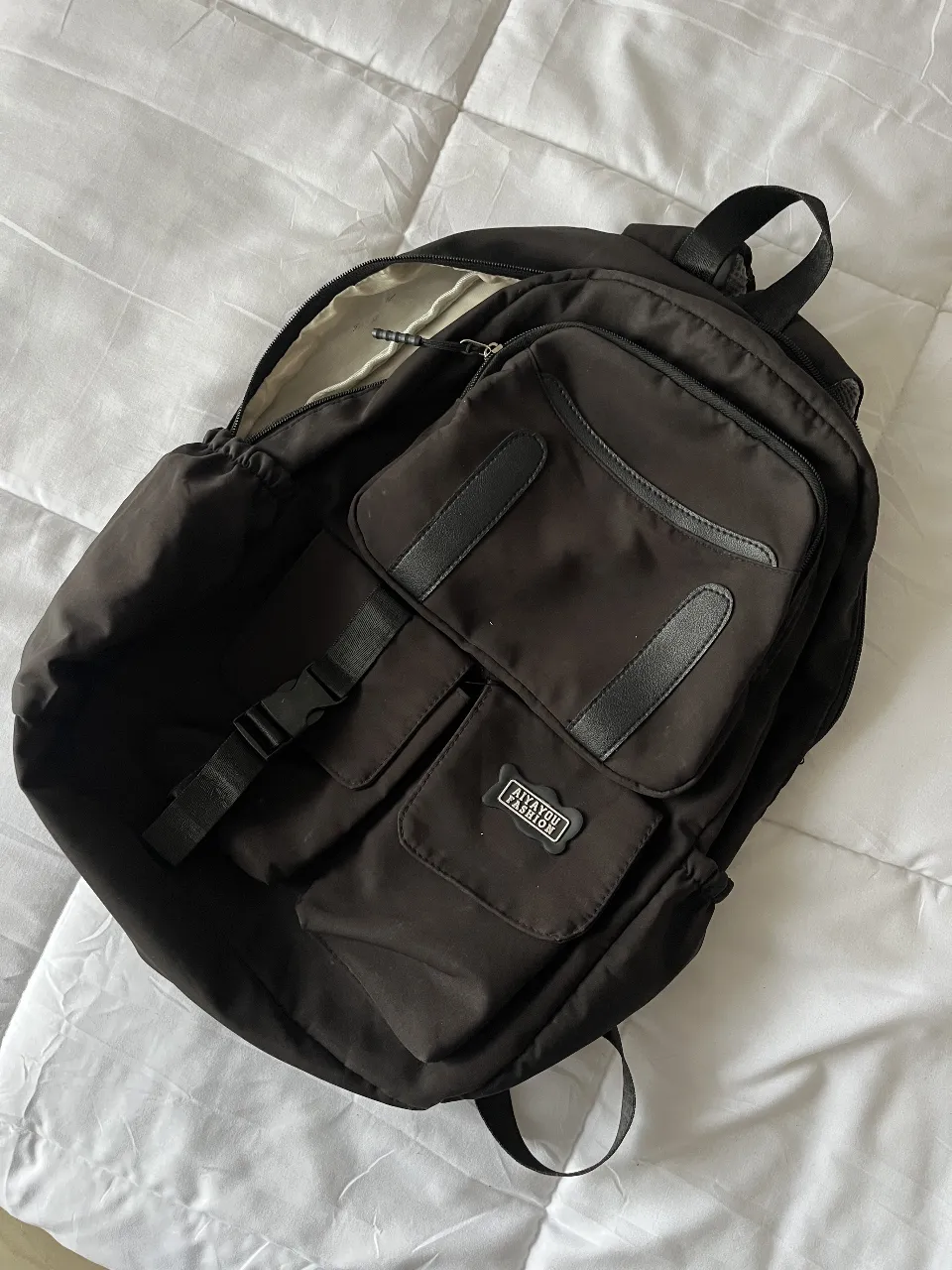 Mochila negra con múltiples bolsillos, ideal para llevar tus pertenencias diarias. Perfecta para un look casual y funcional. Con detalles.
