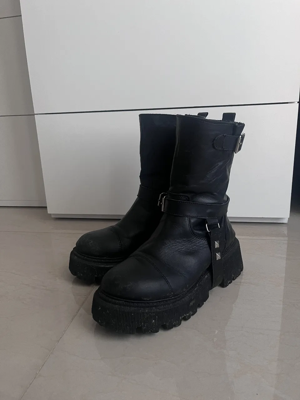 Botas negras de cuero con plataforma y detalles de tachas. Estilo rocker, ideales para un look urbano y con personalidad.