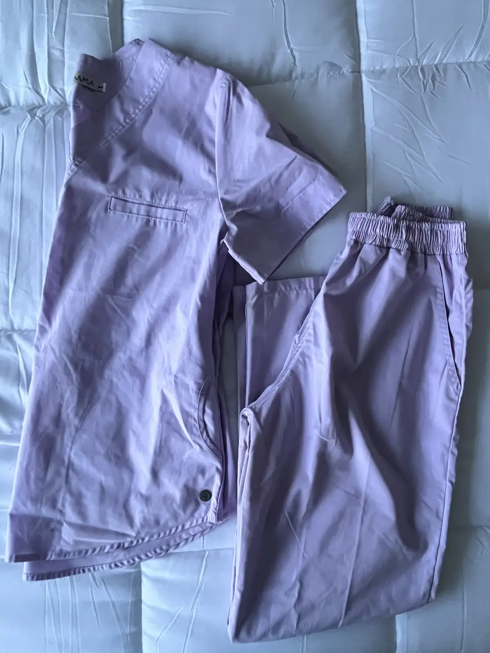 Conjunto de uniforme médico color lila, compuesto por una camisa con bolsillo y pantalón con cintura elastizada. Ideal para profesionales de la salud. MARCA ALABAMA