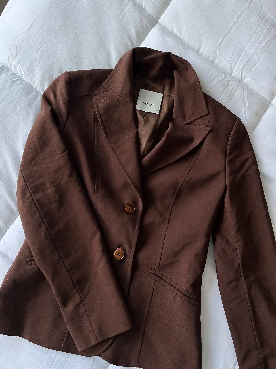 Blazer marrón de mujer, con dos botones y solapas clásicas. Ideal para un look elegante y sofisticado. Forrado por dentro y con hombreras.