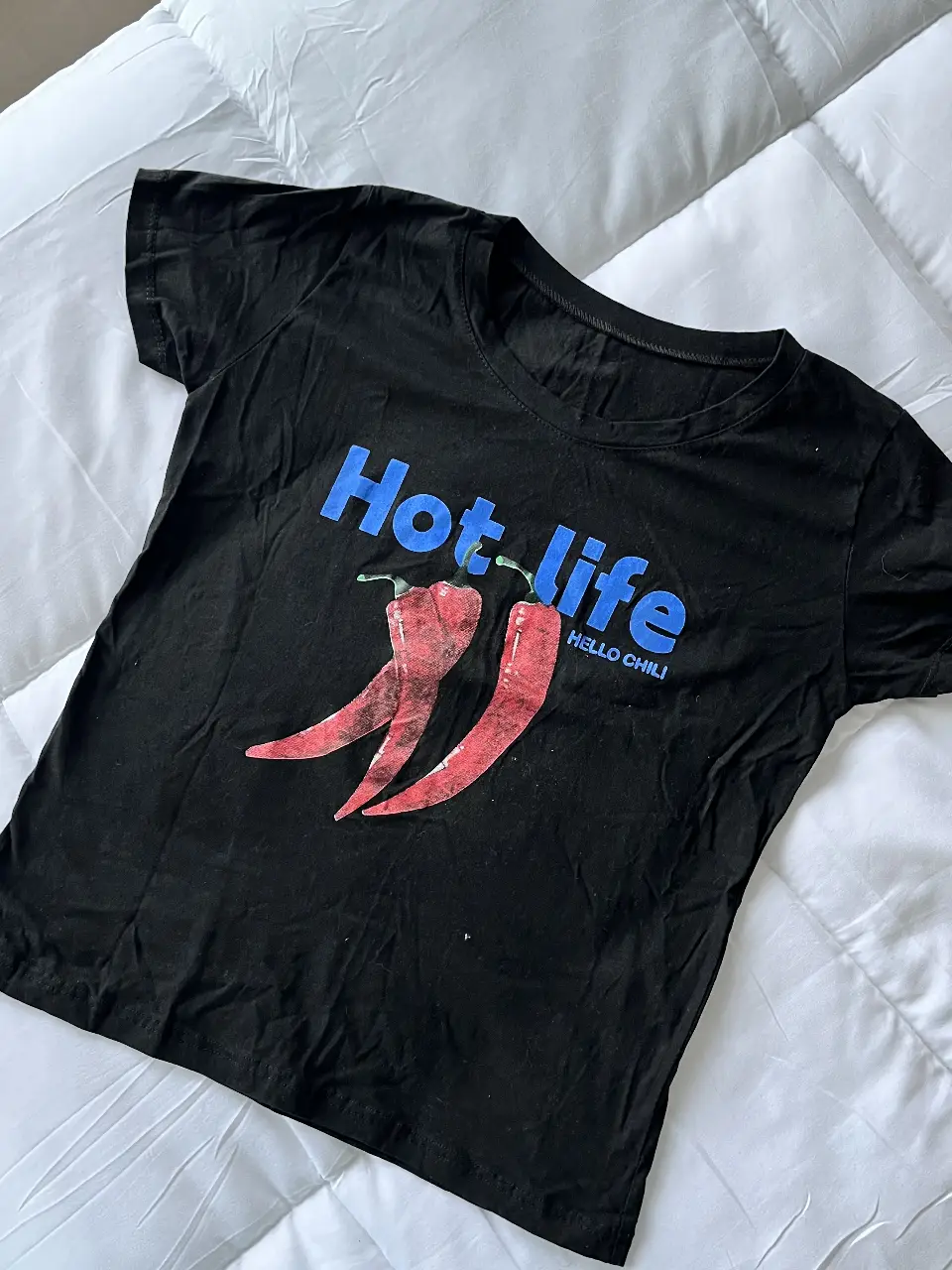 Remera negra con estampado "Hot life" y dos ajíes rojos. Ideal para un look casual y canchero.