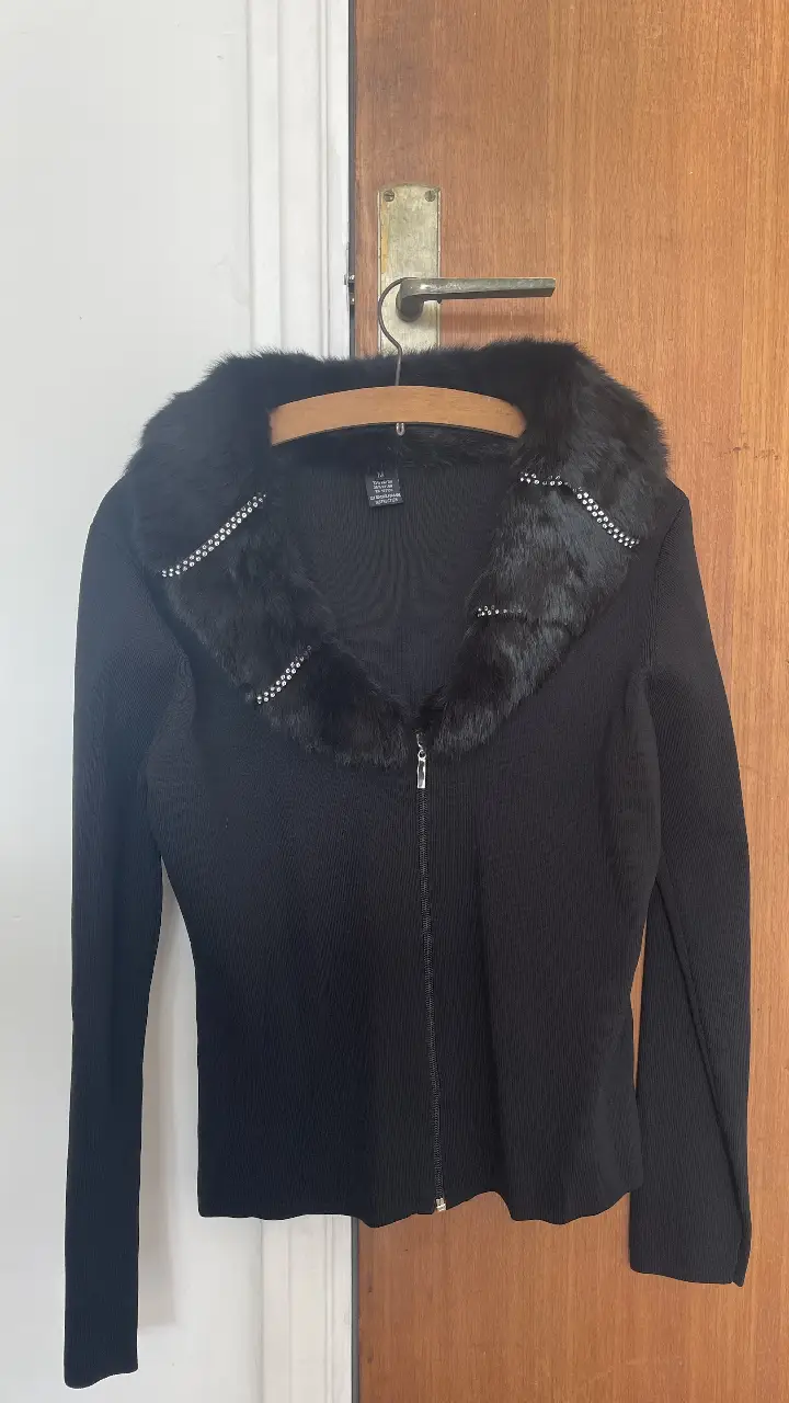 Cardigan negro de mujer con cuello de piel sintética y detalles de strass. Cierre con cremallera. Talle M. Ideal para un look elegante y sofisticado.